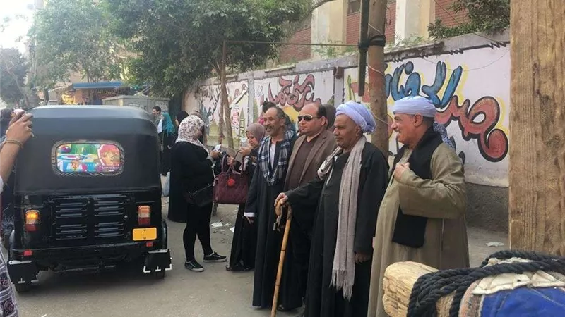 موظفة تساعد المُسنين بلجان شبرا وسط تزايد أعداد الناخبين