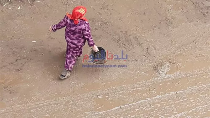 تبلغ من العمر 51 عاما.. سيدة ترفع المياة بالطريق العام تيسيرًا على المواطنين بالمنيا