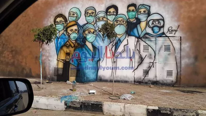 طالب يرسم جرافيتي لدعم الفرق الطبية على واجهة مستشفى صدر المحلة