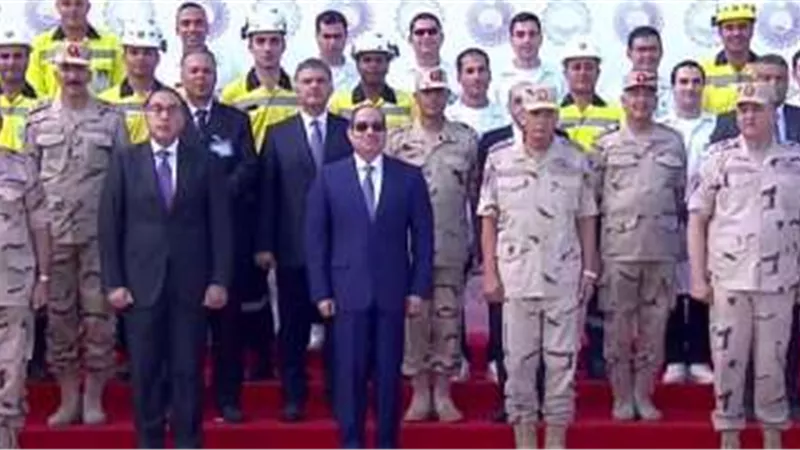 السيسي يلتقط صورة تذكارية مع العاملين بشركة الرمال السوداء