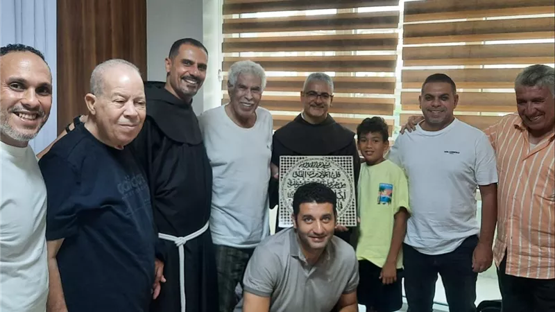 الأب بطرس دانيال يزور الكابتن حسن شحاتة..ويهديه لوحة فنية تحمل آيات الفلق